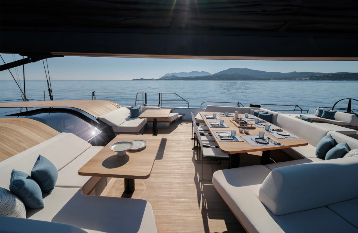 summer outdoor tablescape on yacht with beige ceramic dinnerware set, plates, cups, trays, bowls.