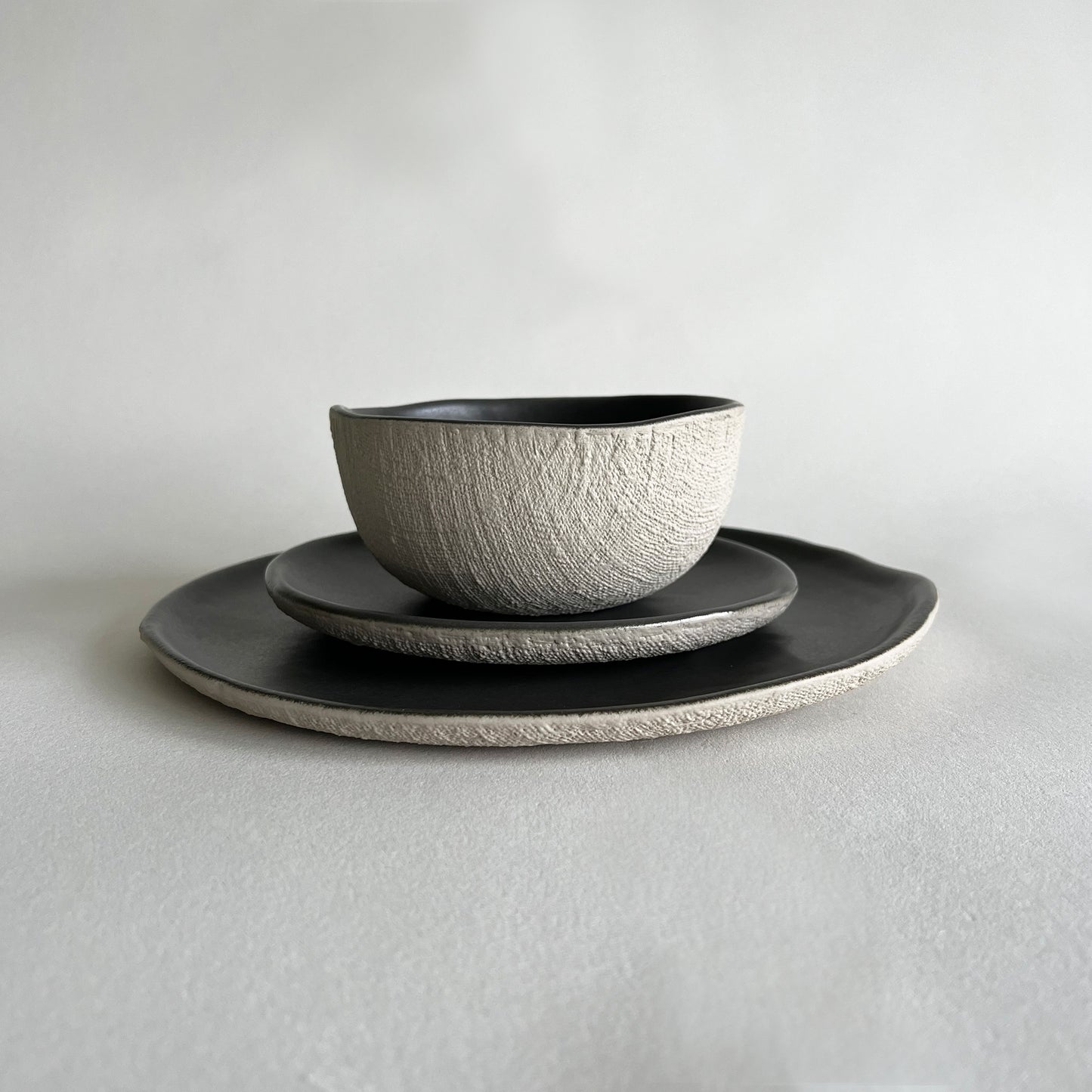 beige and charcoal matte textured handmade ceramic dinner set of dinner plate, starter plate and soup bowl