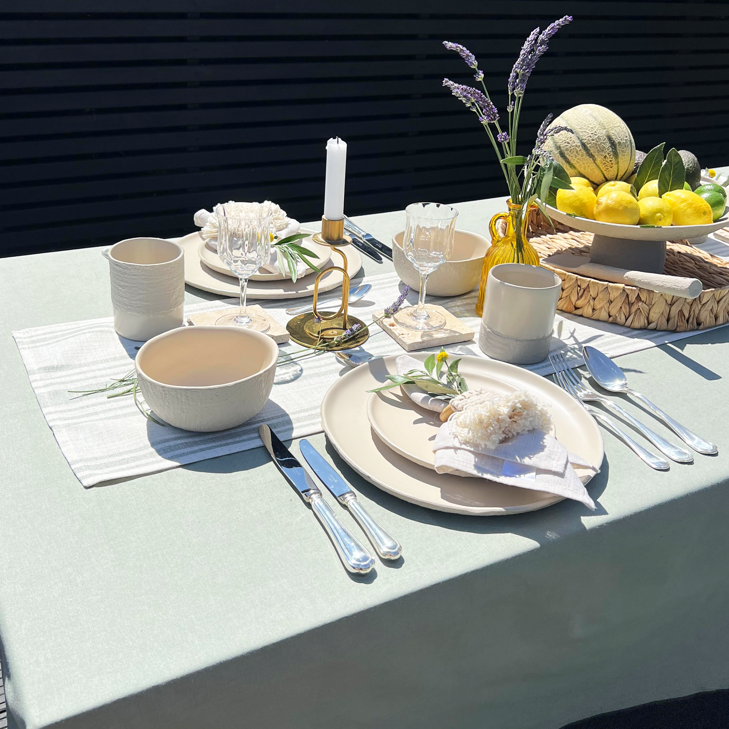 Elegant outdoor table setting with plates, cutlery, and a centerpiece.