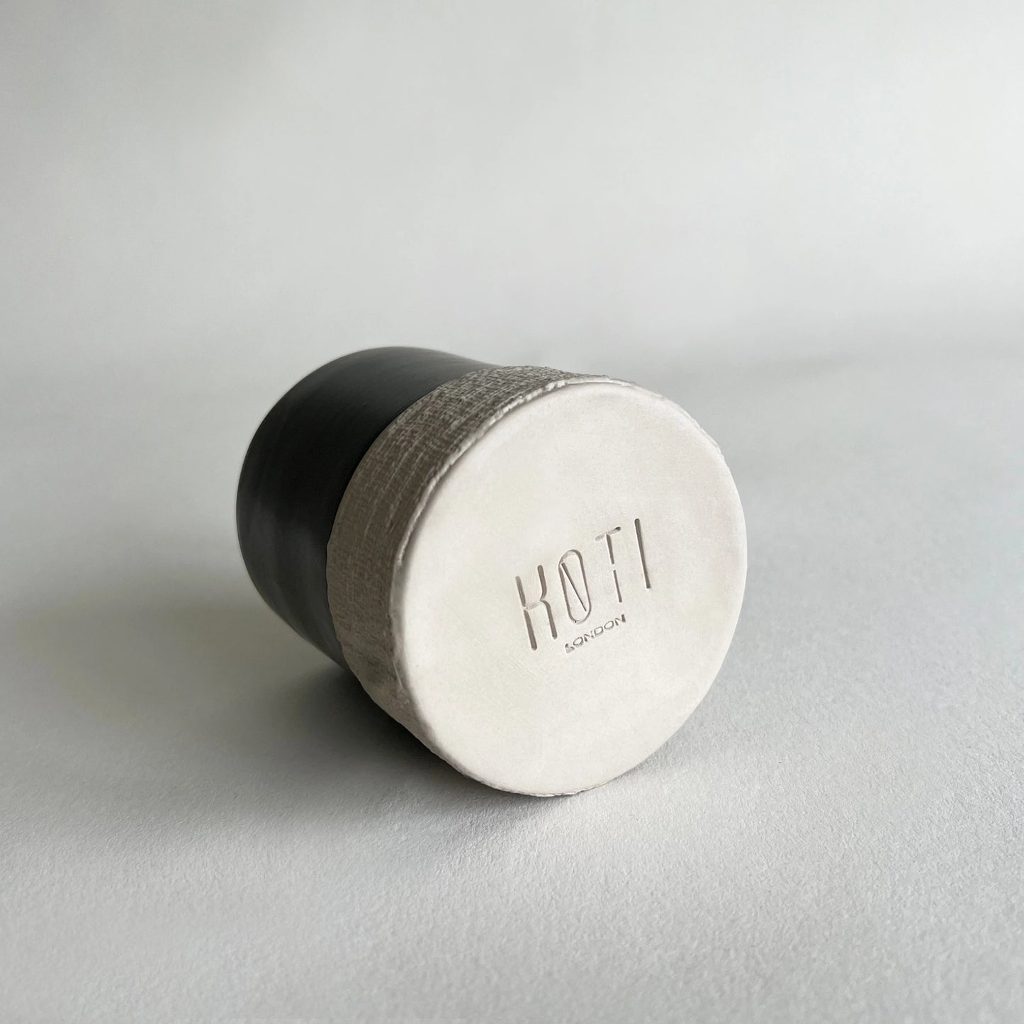 close up detail of handmade ceramic cup, showing the matte finish of the bottom part.