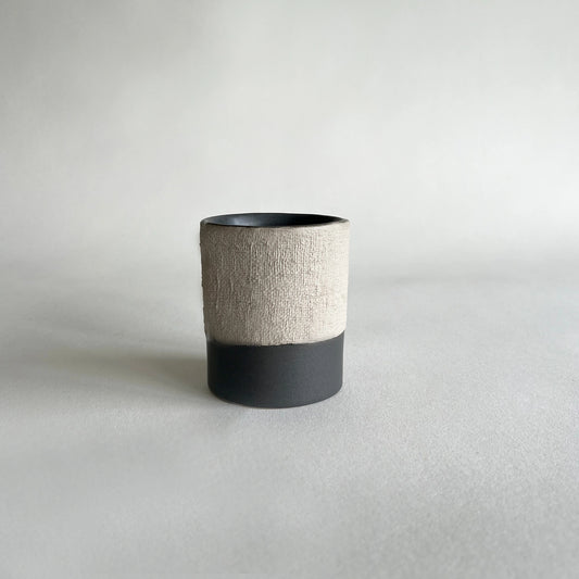 Handmade minimalistic ceramic coffee cup and mug, in matte charcoal colour, contrasted with beige rustic finish.