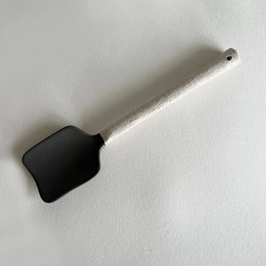 Ceramic serving spoon in two tone colours, using matte charcoal contrasted with beige textured handle.