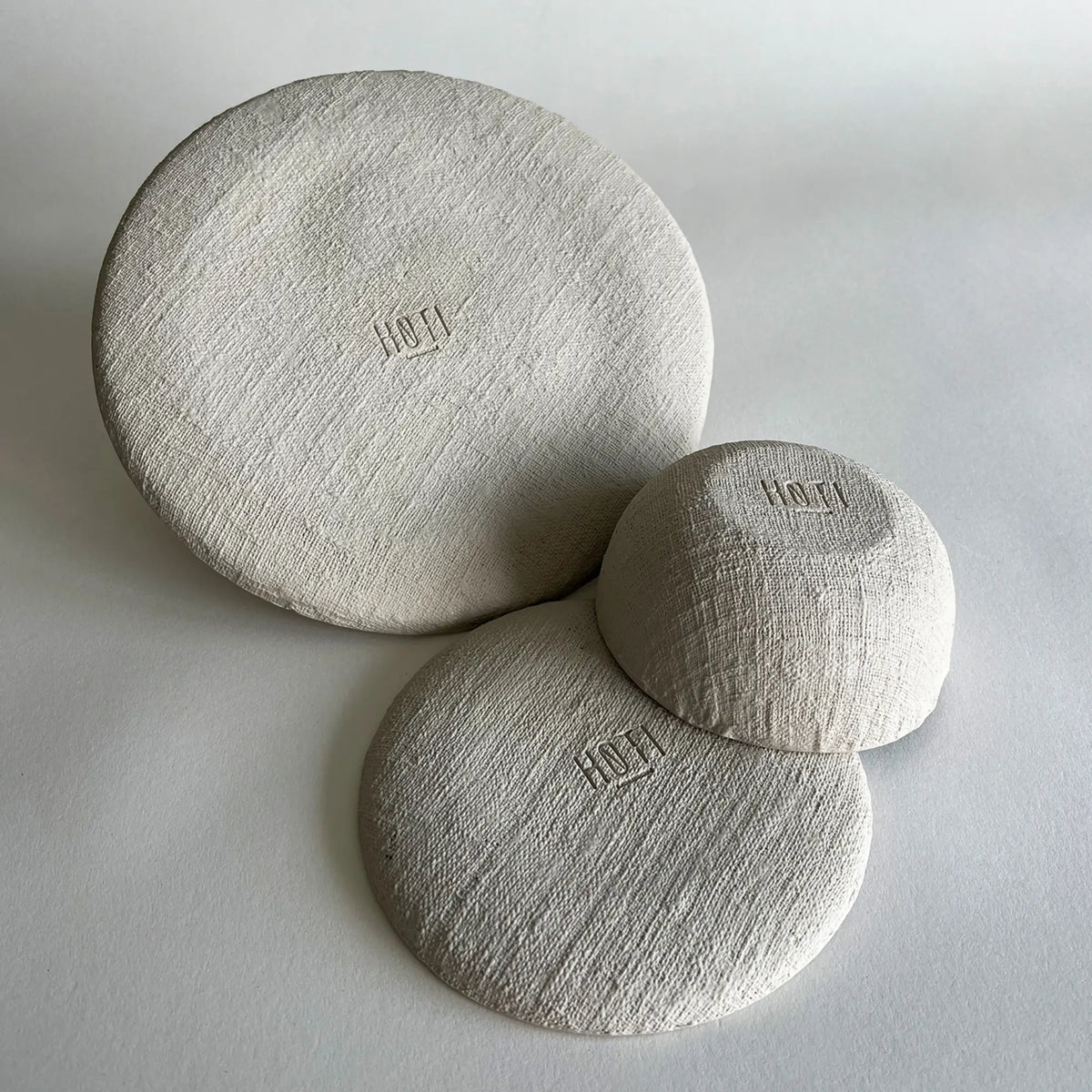 A set of 3 large plates, side plates and bowls showcasing the raw organic texture, handmade dinnerware set in matte finish.