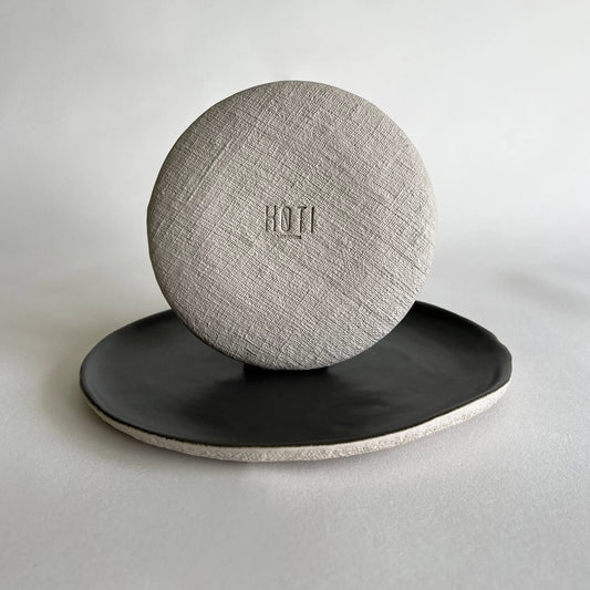Textured light grey stone set of two ceramic plates, large dinner plate in dark charcoal and side plate in dark grey with contrasting beige textured finish.