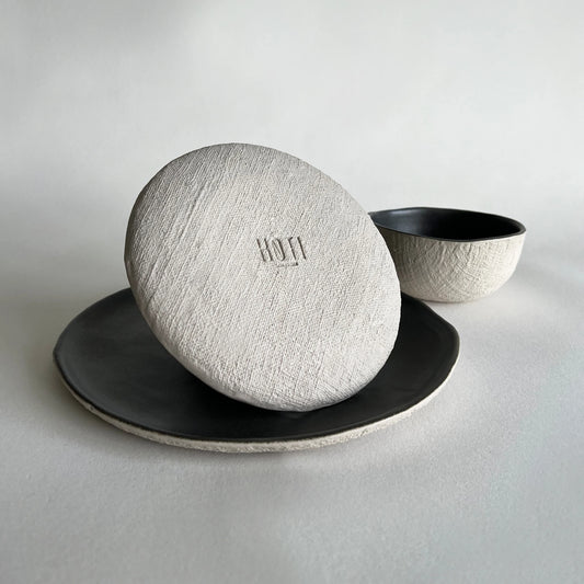 A set of 3 ceramic large pizza plate, side or salad plate and soup bowl, with textured organic finish in beige and charcoal colour.