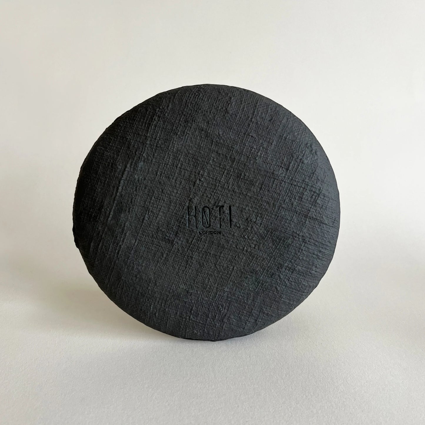 A close up of black matte ceramic dessert plate, showcasing organic textured finish. 