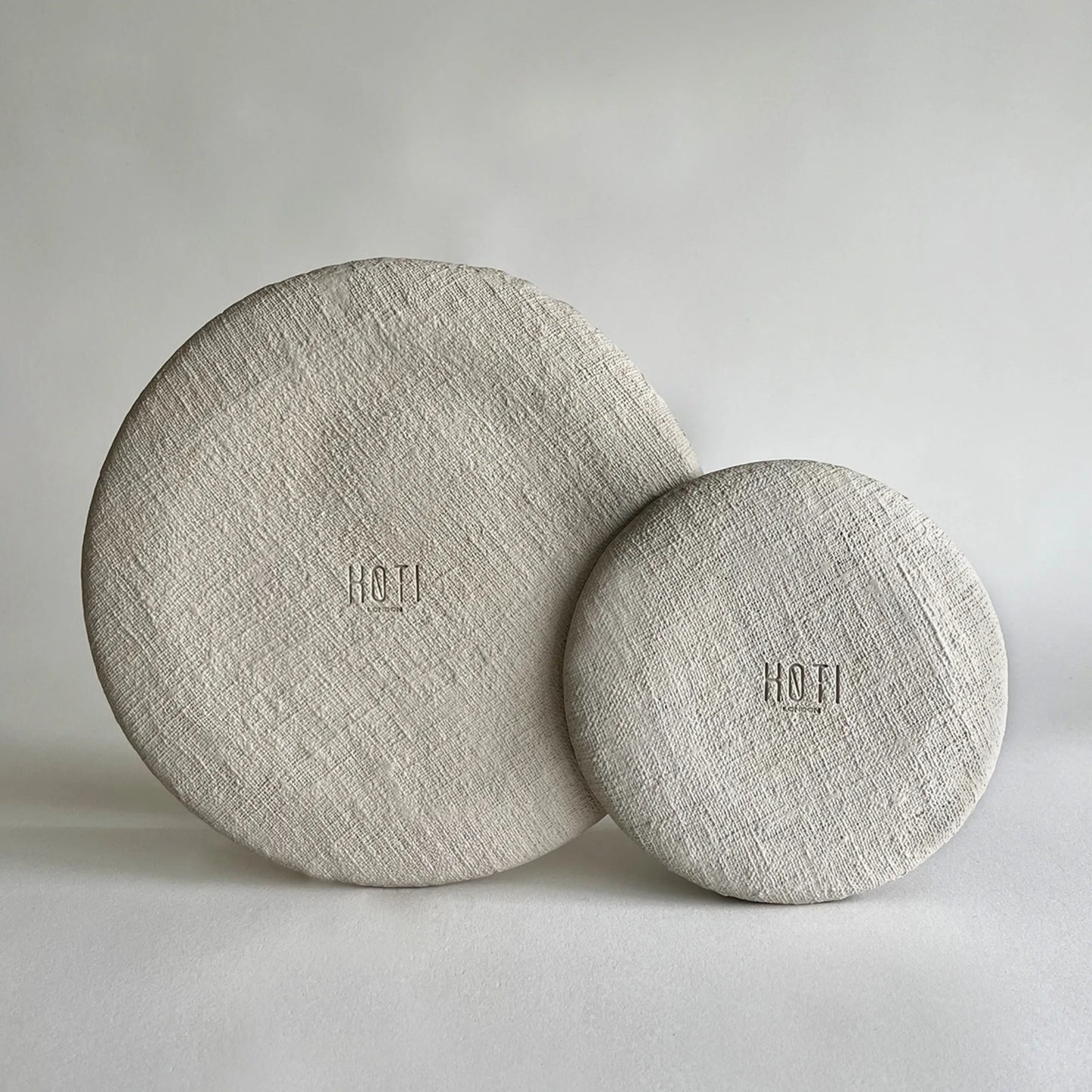 A set of two handmade ceramic plate, showcasing beige organic texture, including large dinner plate and salad or side plate.