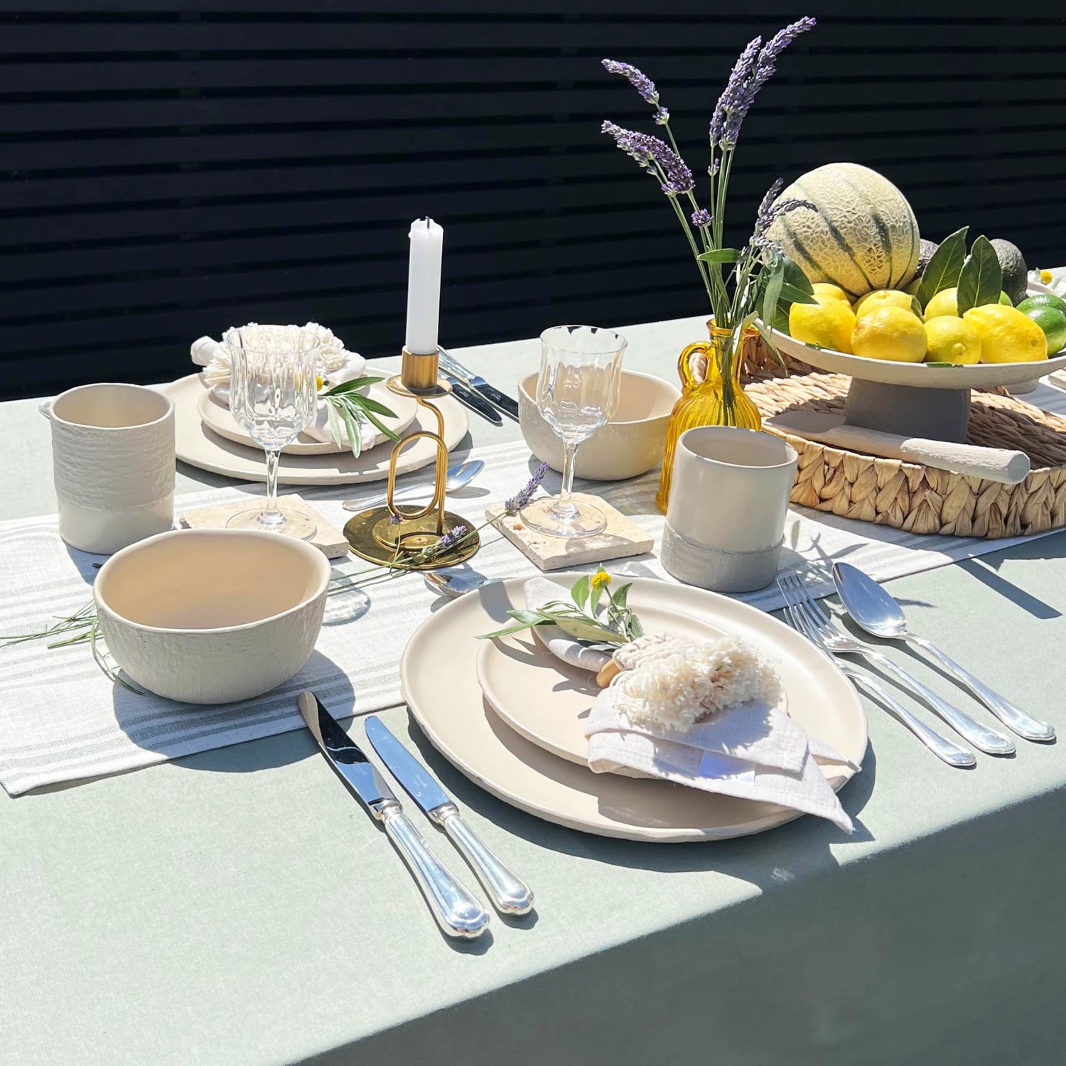 al fresco table setting in sage and beige colour using earthy tones, with textured handmade ceramic plates, cups and bowls